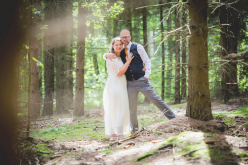Hochzeitspaar umarmt sich im Wald