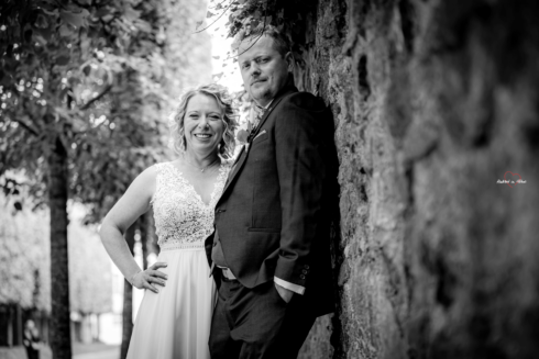 Brautpaar in Lichtenwalde lehnt an einer Mauer