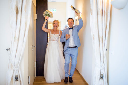 Jubelndes Brautpaar kommt aus dem Traussal