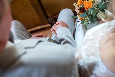 Hochzeitspaar, dass sich während der Trauung im Kloster Nimbschen an den Händen hält