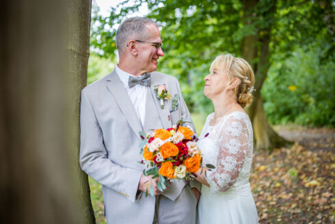 Brautpaar im Kloster Nimbschen schaut sich lächelnd an der Ruine in die Augen