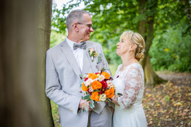 Brautpaar im Kloster Nimbschen schaut sich lächelnd an der Ruine in die Augen