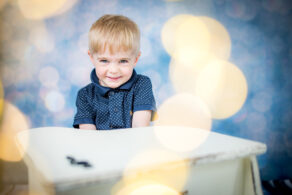 Kleiner Junge lächelt verschmitzt in die Kamera